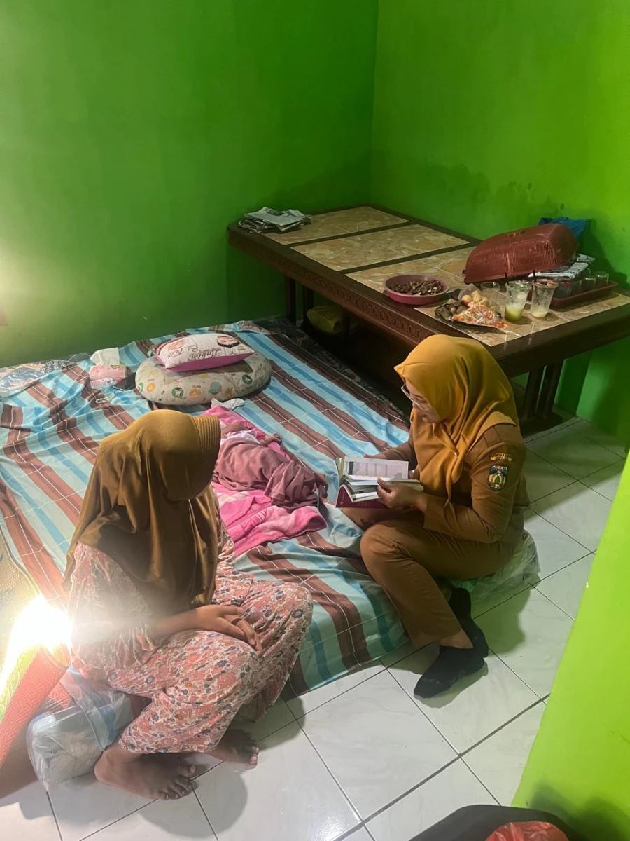 Kunjungan rumah bidan desa dan pembina posyandu ke rumah ibu Trisni yang baru melahirkan 