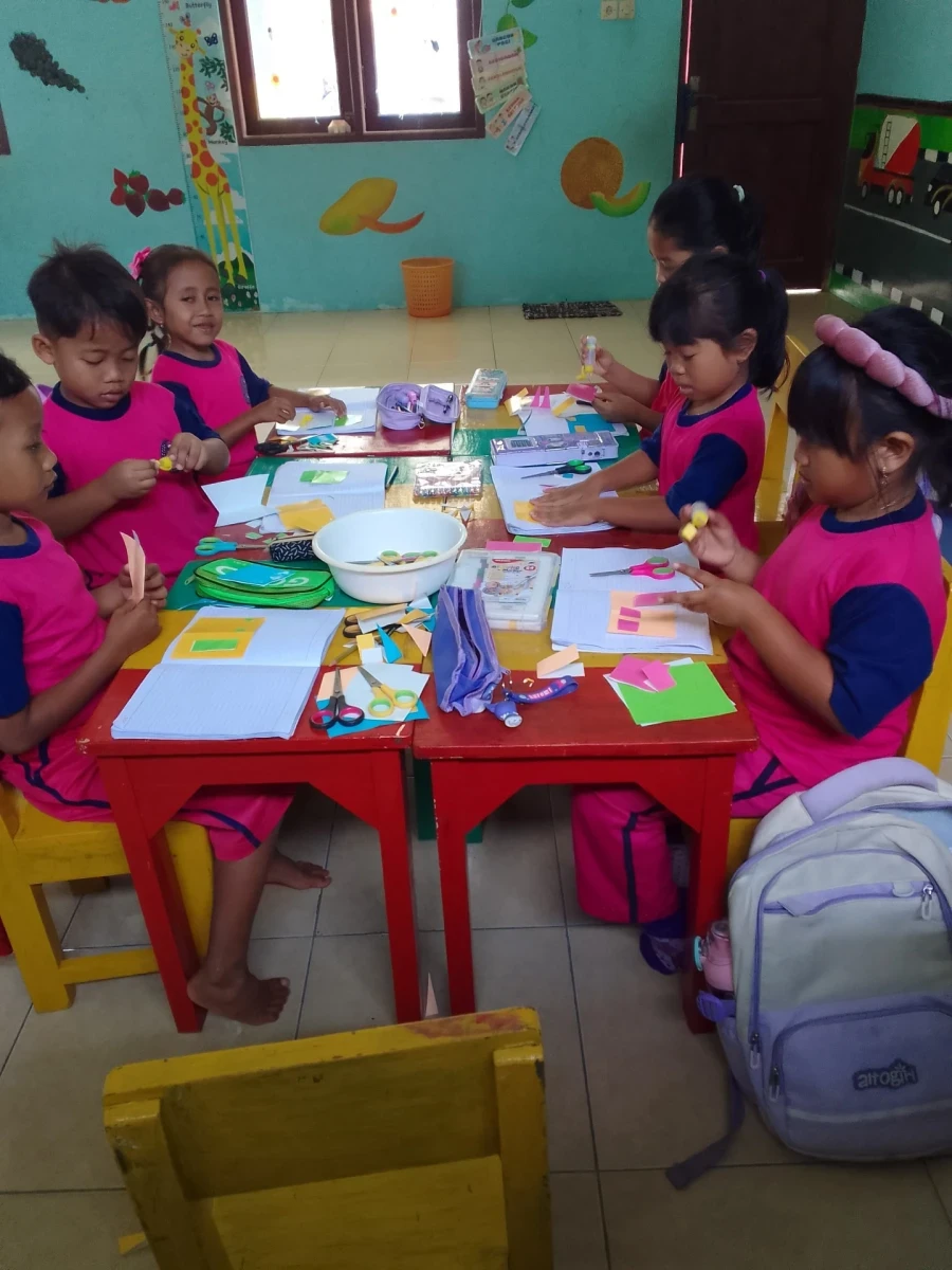 Menempel kertas origami membuat rumah 