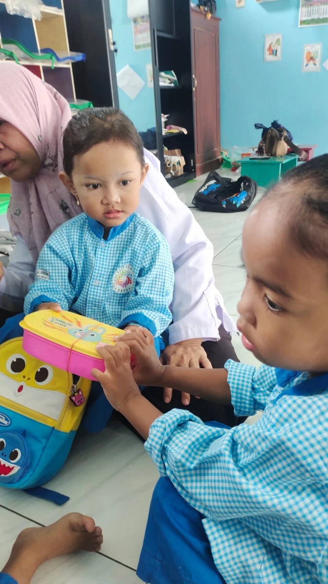 Anak berbagi makanan dengan temannya 