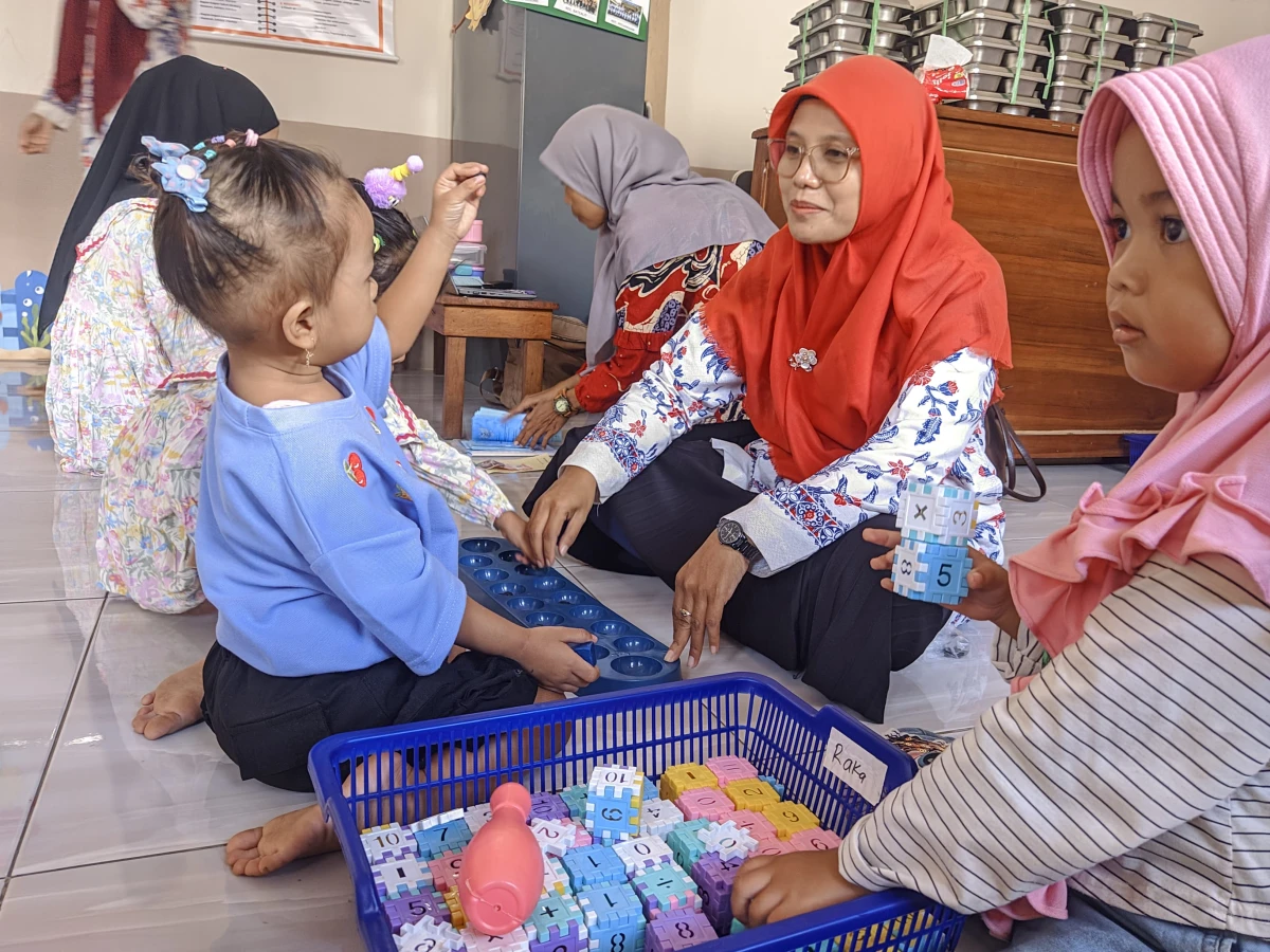 Bunda literasi sengonbugel mengajari murid PP Melati bermain permainan tradisional dakon
